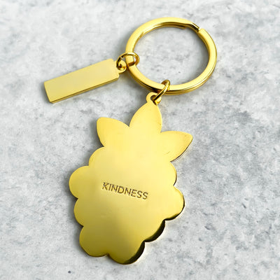 White and gold raspberry metal keychain is the icon of our brand. Hard enamel filled and sealed. Each one is durable and waterproof. The back side of keychain features a word "KINDNESS" on solid gold background.