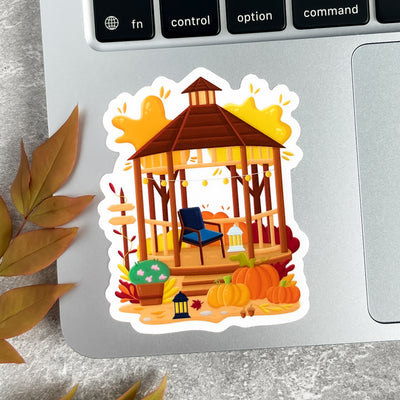 Sticker of a wooden gazebo with pumpkins on a laptop keyboard.