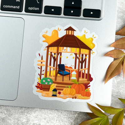 Sticker of a gazebo with pumpkins and autumn leaves on a laptop.