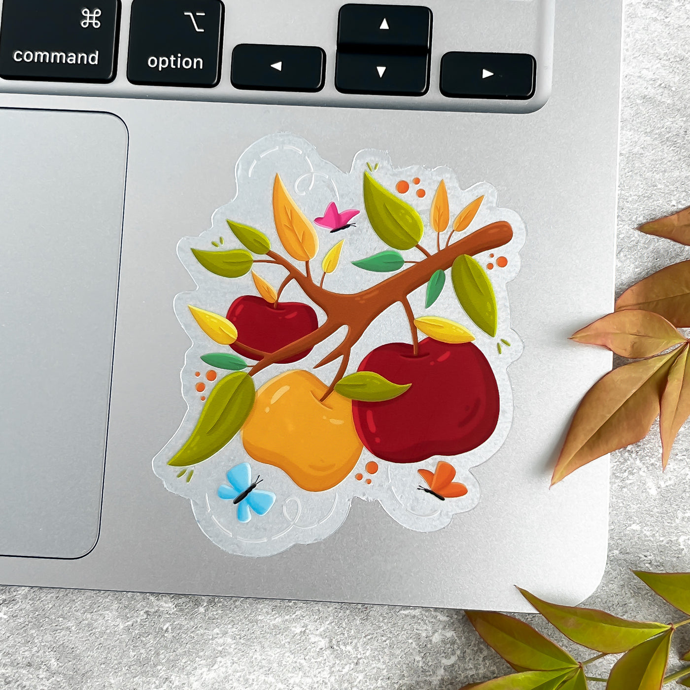 Colorful sticker of apples and leaves on a laptop.