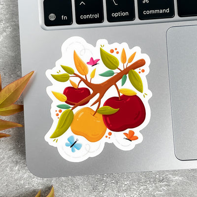 Colorful sticker of apples and leaves on a laptop keyboard.