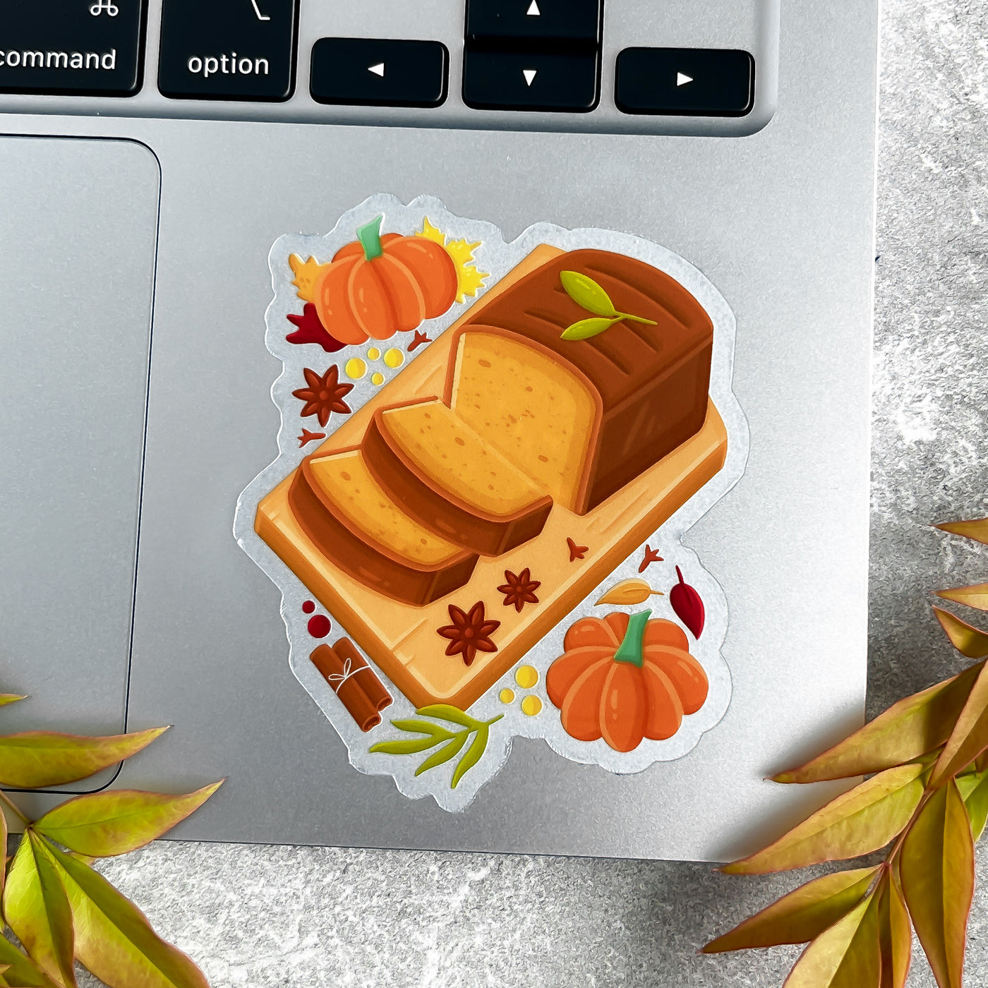 Sticker of a loaf of bread with pumpkins on a laptop keyboard.