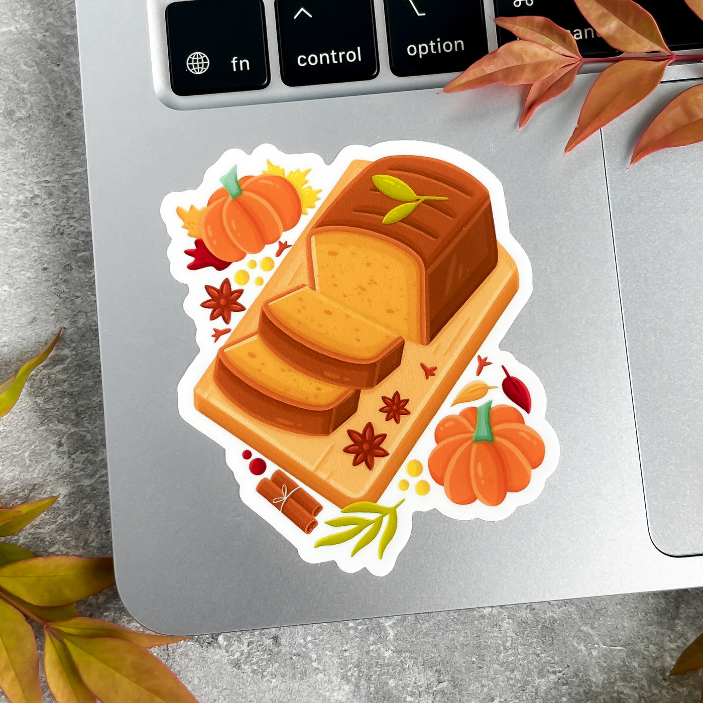 Sticker of a loaf of bread with pumpkins and leaves on a laptop.