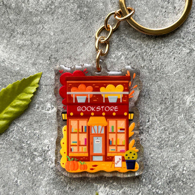 Keychain with a book store design on a gray surface.