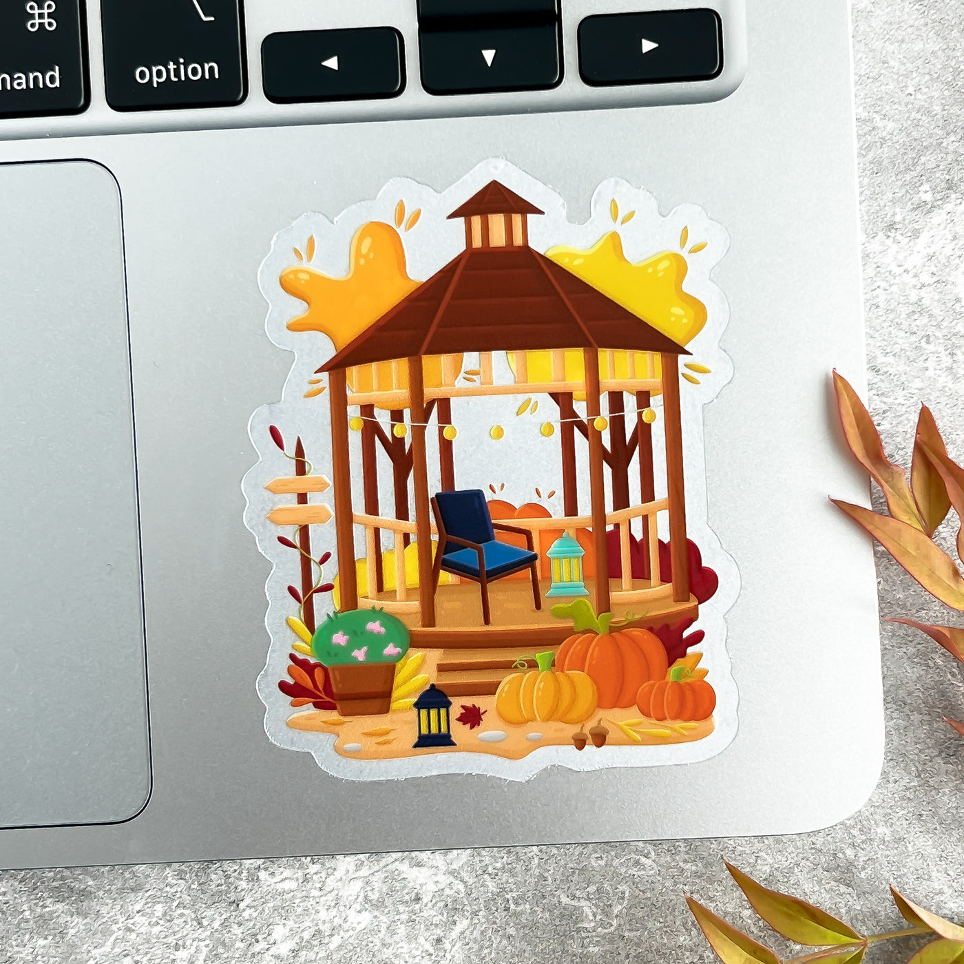 Sticker of a wooden gazebo with pumpkins on a laptop.