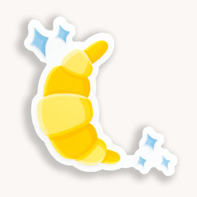 Croissant vinyl sticker, offered in classic white with white background and white border or clear sticker with a solid white backing, but is clear once the backing is removed. Food stickers by Simpliday Paper by Olga Nagorna.
