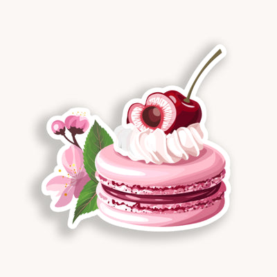 Sticker of a pink macaron with whipped cream and a cherry on top, surrounded by cherry blossoms.